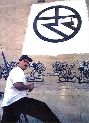 A unity artist is photographed painting a giant unity symbol mural in Downtown LA during the early 90s