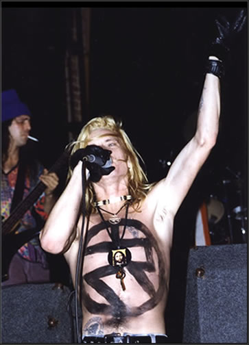 Patrick Stone of Mondo Cane performs with a giant unity symbol painted on his body for a performance at the Whisky A Go Go on the Sunset Strip in Hollywood