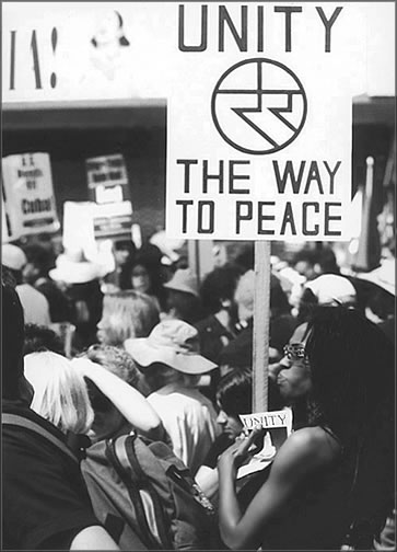 A peace activist holds a unity sign with a large unity symbol during an anti-Iraqi War pre-conflict rally held on Hollywood Blvd in Los Angeles on March 20, 2004
